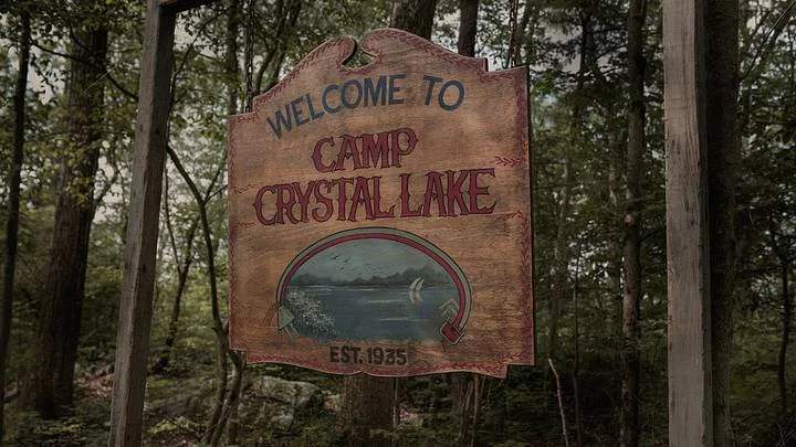 The wooden Camp Crystal Lake sign among the trees