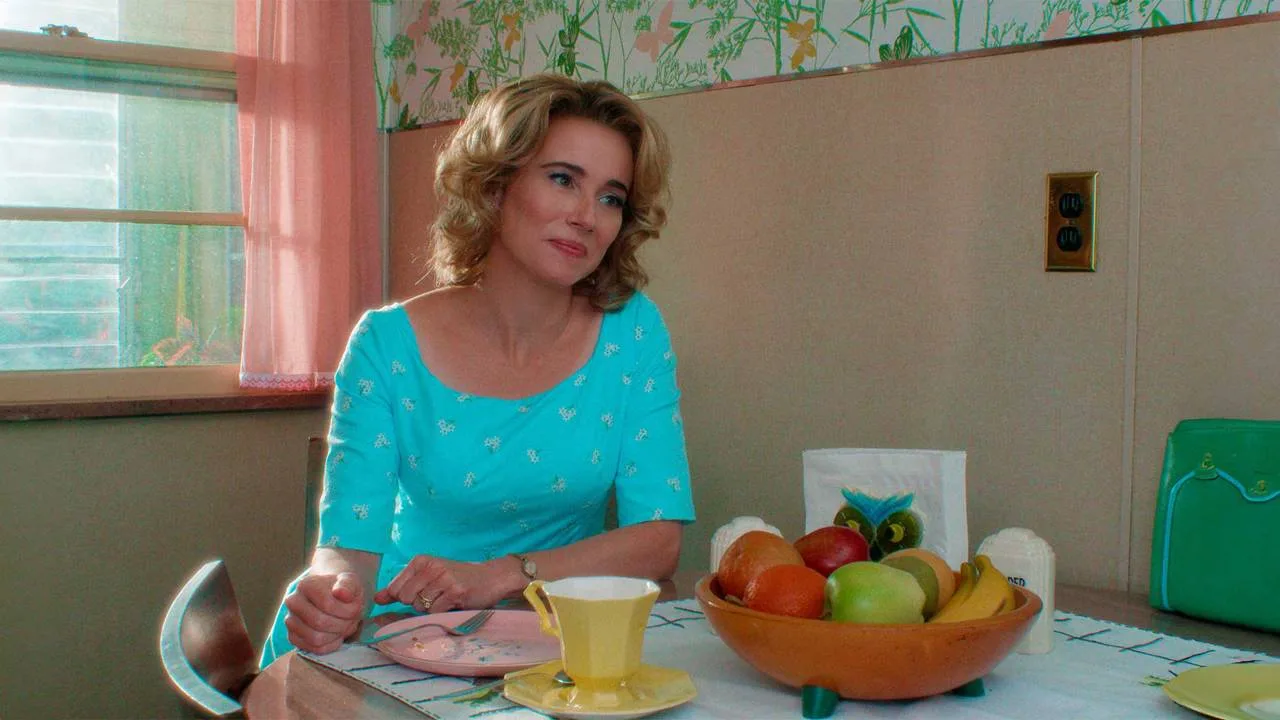 Pam sits at a brightly colored kitchen table in the flashback